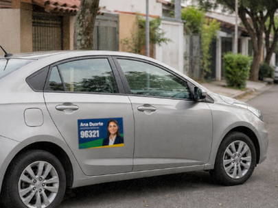 Fotografia realista de um carro de passeio com um adesivo discreto e bem posicionado na porta traseira, estacionado numa rua residencial durante o dia, sem cobrir vidros ou placa.