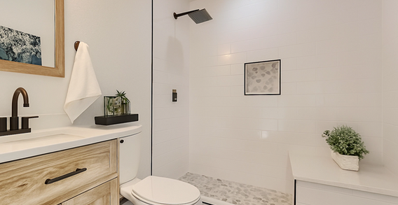 Bathroom featuring wood vanity, black fixtures, and wood framed mirror.