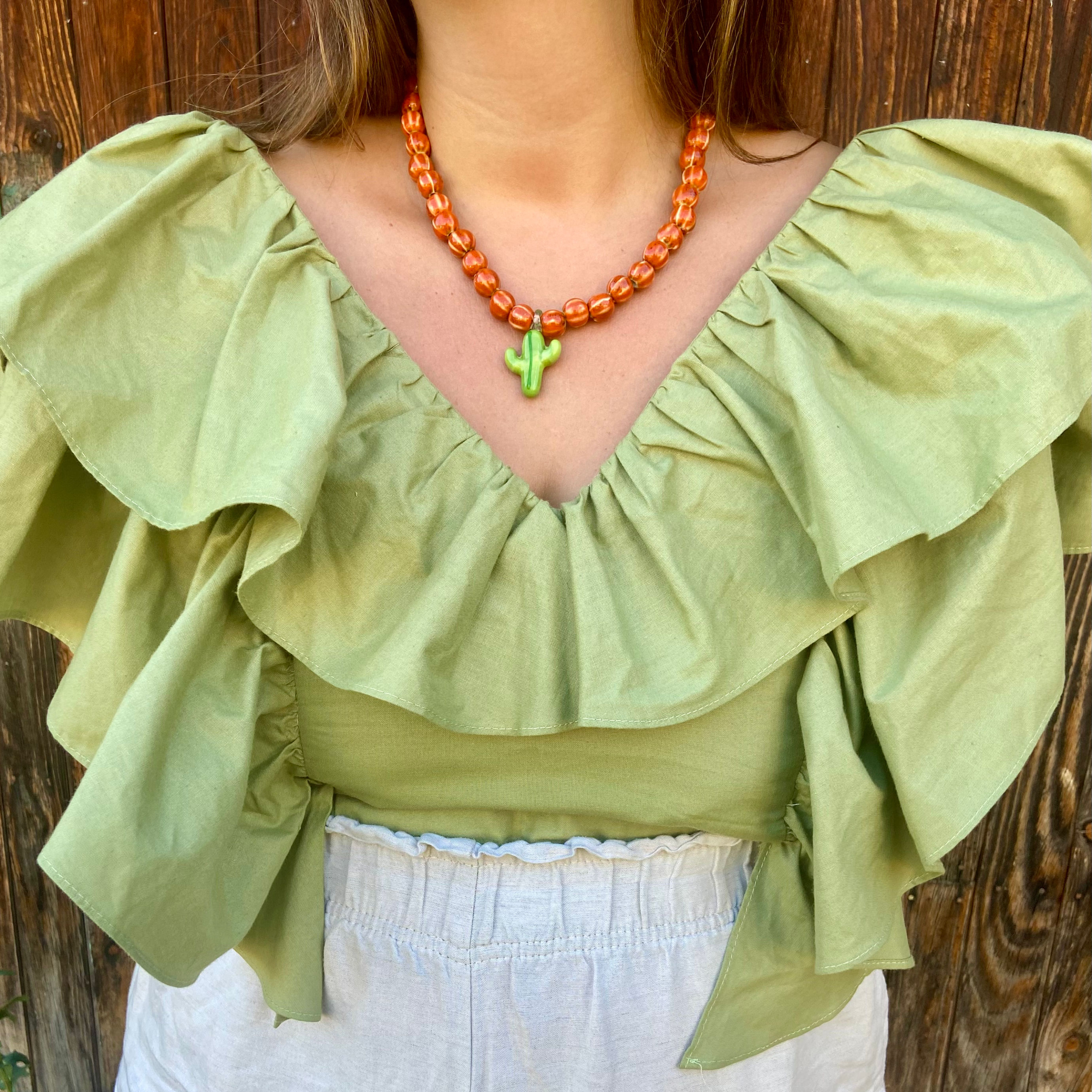 Collar Nuquí cerámica naranja con charm cactus