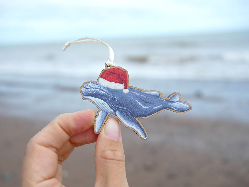 Thumbnail: A wooden Christmas tree decoration of an illustrated humpback whale in a santa hat.