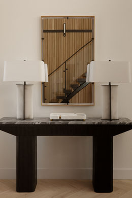 Modern and bright Los Angeles entry way with black console table, white lamps and mirror.