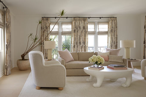 Designed by Ethan Charles Design, a living room with neutral backdrops let the details surface: bespoke lighting, statement draperies, and roman shades.