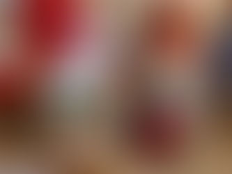 Kreppipaperista valmistettu joulutonttu istuu puun päällä ja polttaa piippua