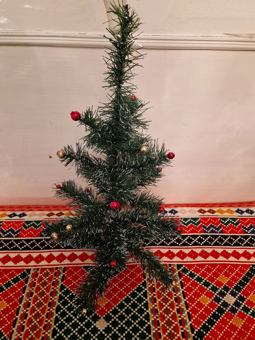 Vanha pieni pöytöjoulukiisi koristeltu lasipalloilla