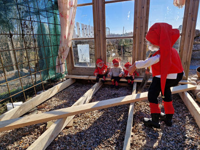 Tonttu-ukot korjaavat terassin laudoitusta, auringon säteet siivilöityyvät kauniisti vanhojen ikkunoiden läpi