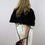 Thumbnail: The rear view of a woman wearing an elegant capelet in black faux fur.