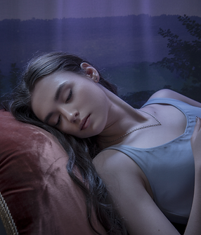 A serene person with closed eyes lying back on a cushion, soft light around them, or an ar