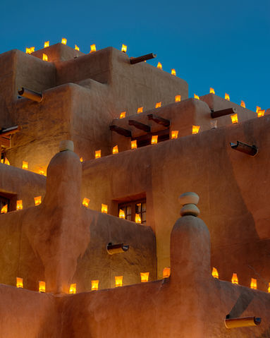Large adobe building decorated with luminaria for the holidays.jpg