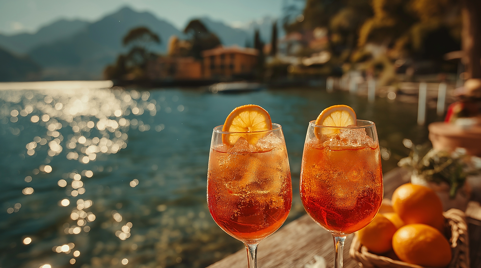 Two orange cocktails with ice and lemon slices on a wooden table by a sparkling lakeside at sunset, warm and relaxing