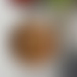 Bowl of Deconstructed Cabbage Roll Soup with Brussels sprouts, ground pork, tomato, and rice, garnished with Parmigiana Regina and parsley.