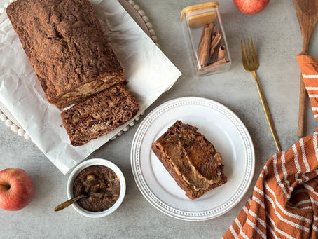 A sliced loaf of cardamom apple cinnamon bread with a buttery cinnamon crumble topping and small pieces of apple baked into the bread.