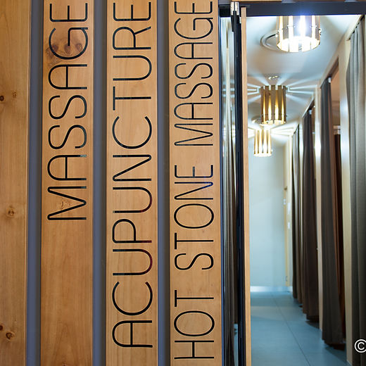 Business lifestyle photography of a serene hallway with a 'Massage Therapy' sign, guiding clients to a space for rejuvenation and comfort.