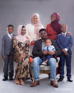 Studio portrait of an extended family of seven, dressed in elegant and traditional outfits.