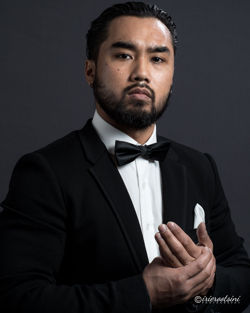Tuxedo bow tie headshot pose with a serious expression and hand gesture
