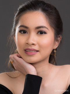 Studio headshot of woman with earrings, soft light and neutral background for natural skin tones.
