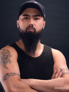 Tough acting headshot pose with beard in black tank top, arms crossed