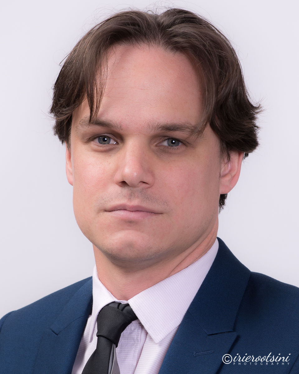 A professional man in a suit and tie poses confidently for a corporate headshot in Sevenhills.