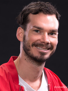 Professional acting headshot with natural smile in red jacket, Sydney studio