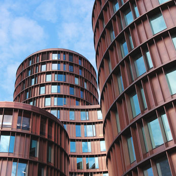 Modern copper-clad cylindrical buildings against a blue sky