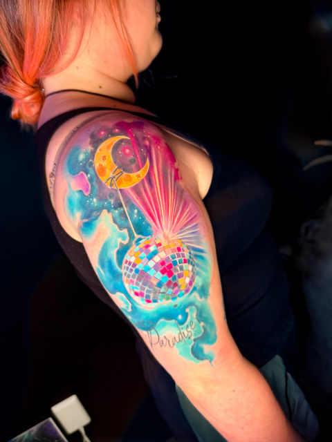 Custom tattoos by Amy Zager, a Denver-based, LGBTQ+ friendly female tattoo artist known for vibrant watercolor tattoos, galaxy designs, detailed portrait tattoos, and expressive animal tattoos. Amy specializes in large-scale illustrative realism and glitter-style tattoos, with a focus on storytelling through art. Her work blends fine art techniques with bold color and emotional depth. Available for bookings in Denver and frequent guest spots in Chicago, Oakland, Seattle, San Diego, and beyond.