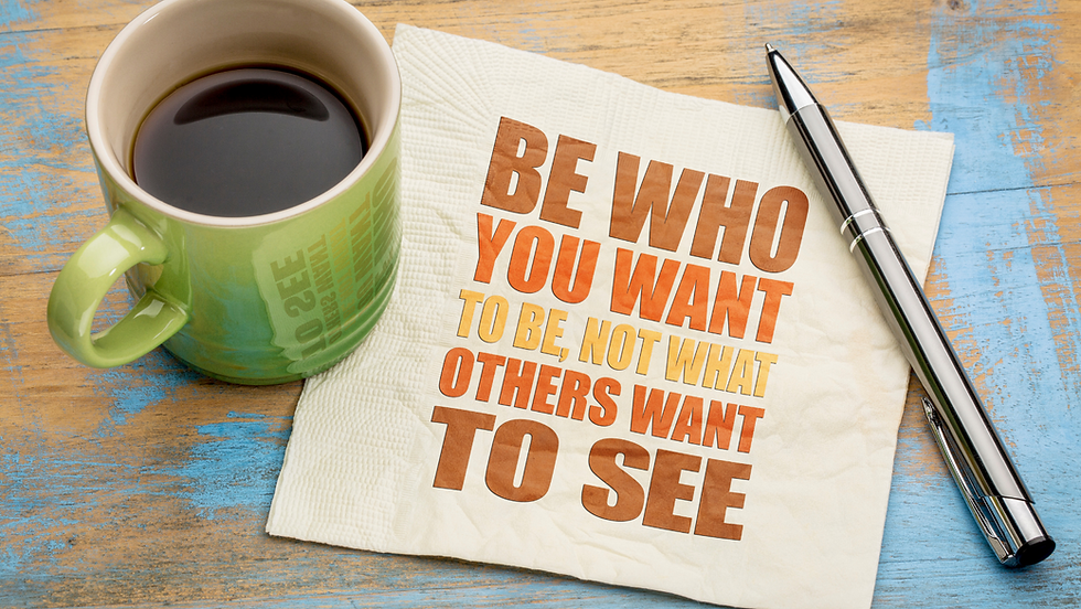 Tazza di caffè accanto a una tovaglietta con la scritta “Be who you want to be, not what others want to see”, simbolo del desiderio di autenticità e della ricerca di una voce personale nel proprio percorso di vita e lavoro.