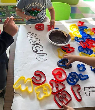 children painting with alphabet letters