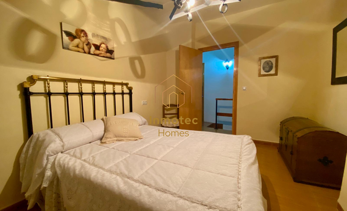 Fourth bedroom with double bed, wooden floor and traditional decor in a country house in Chirivel, Almería.