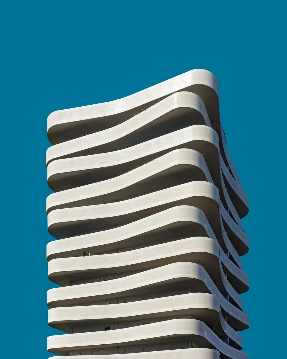 Modern white building with curved balconies against blue sky