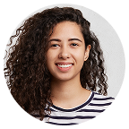 Smiling woman with long curly hair in a striped shirt.