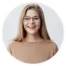Smiling young woman with glasses and long hair.