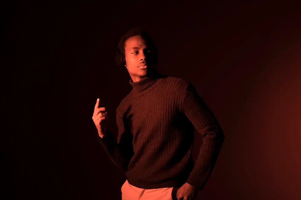 Man in a brown turtleneck under dramatic red lighting