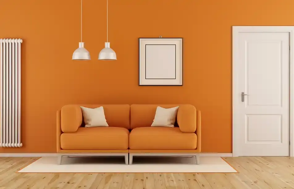 Orange sofa in modern living room with art, door and lights.