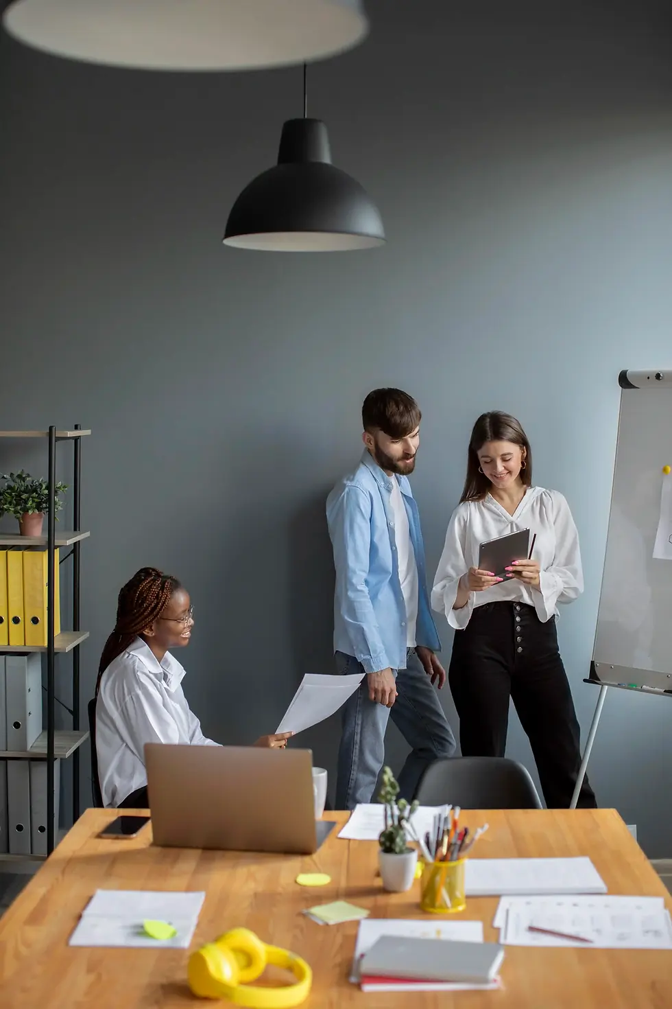 Three colleagues collaborating in a modern office.