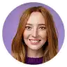 Smiling woman with long reddish-brown hair against a lavender background.