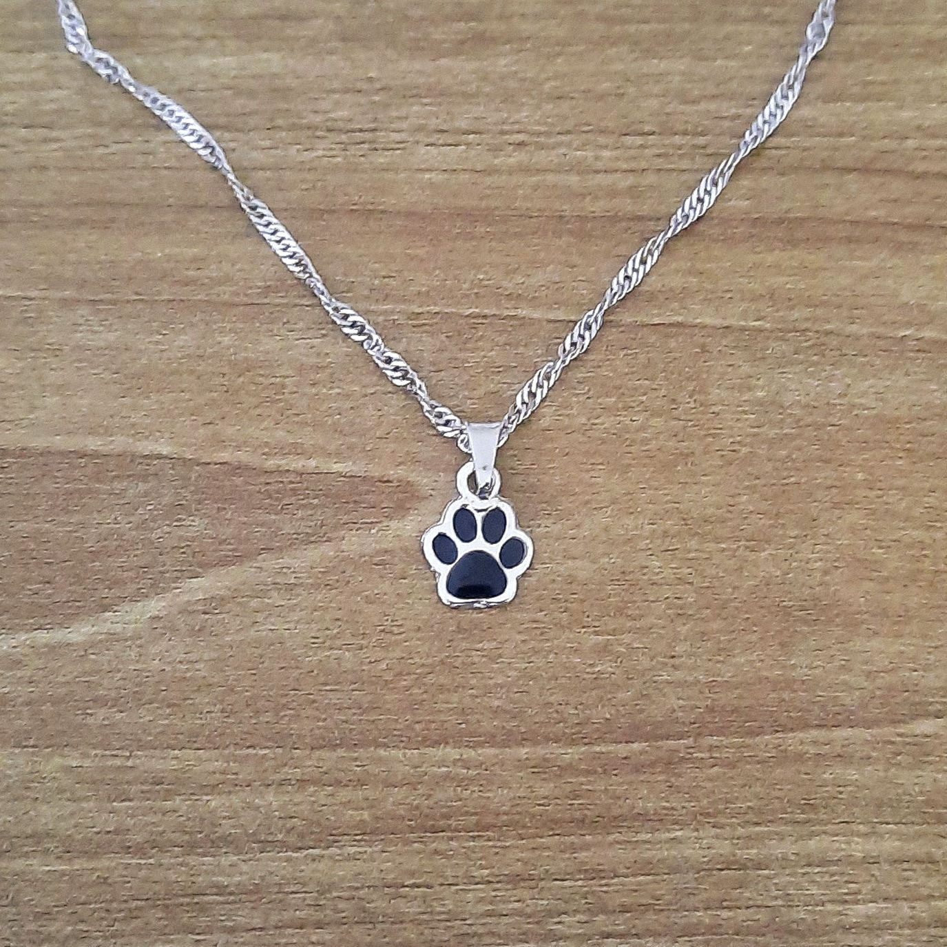 Colar  mini patinha com resina preta no banho do ouro branco 