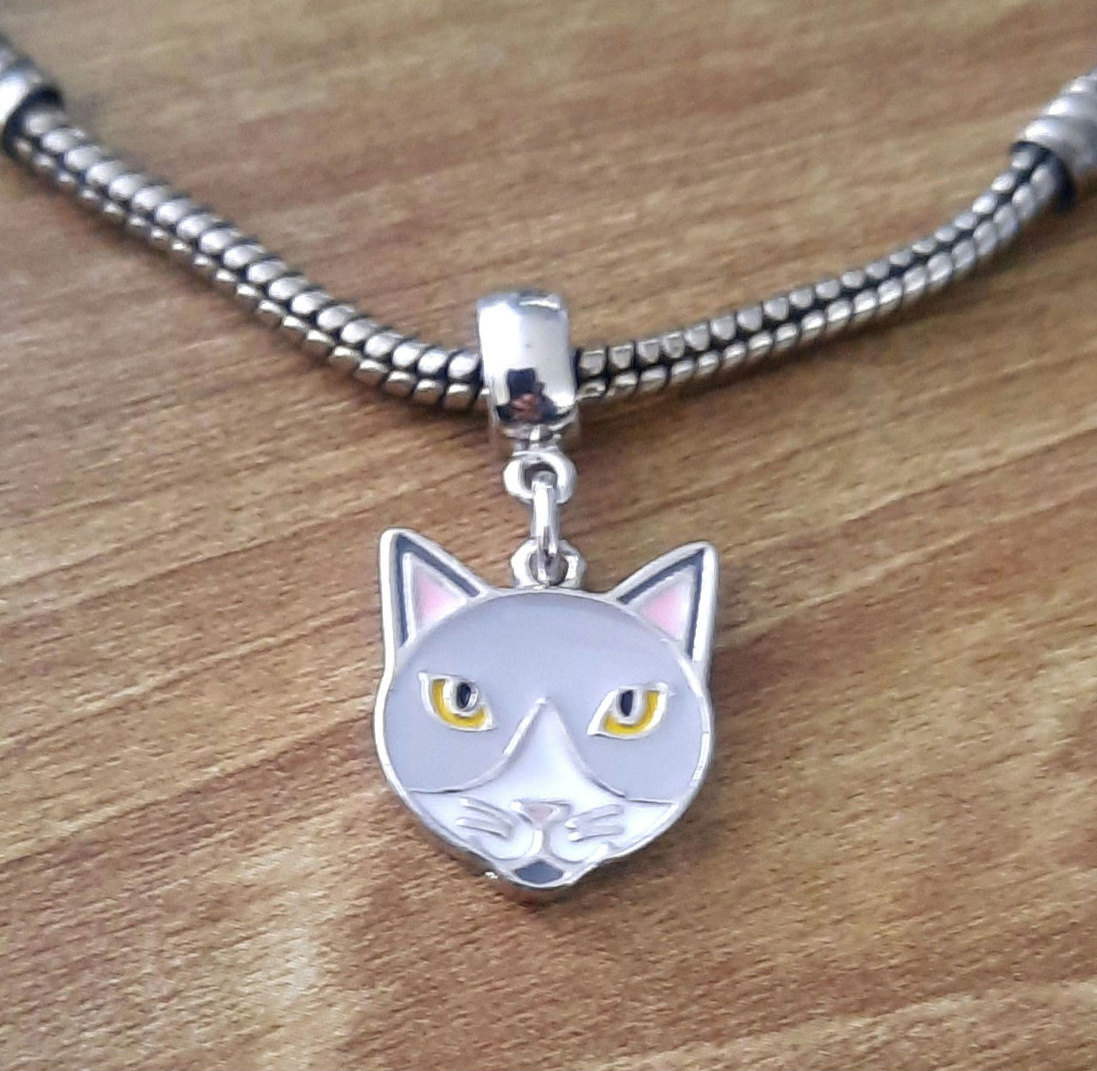 Berloque carinha gato cinza resinado no banho do ouro branco