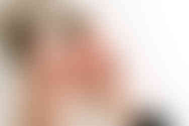 Close-up detail during newborn session in Guelph, Ontario showing adult hands gently holding newborn baby’s feet