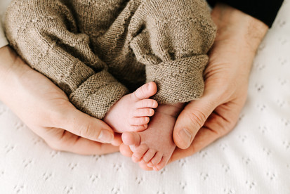 Close-up newborn session in Guelph, Ontario showing baby toes and knit leggings in soft neutral tones