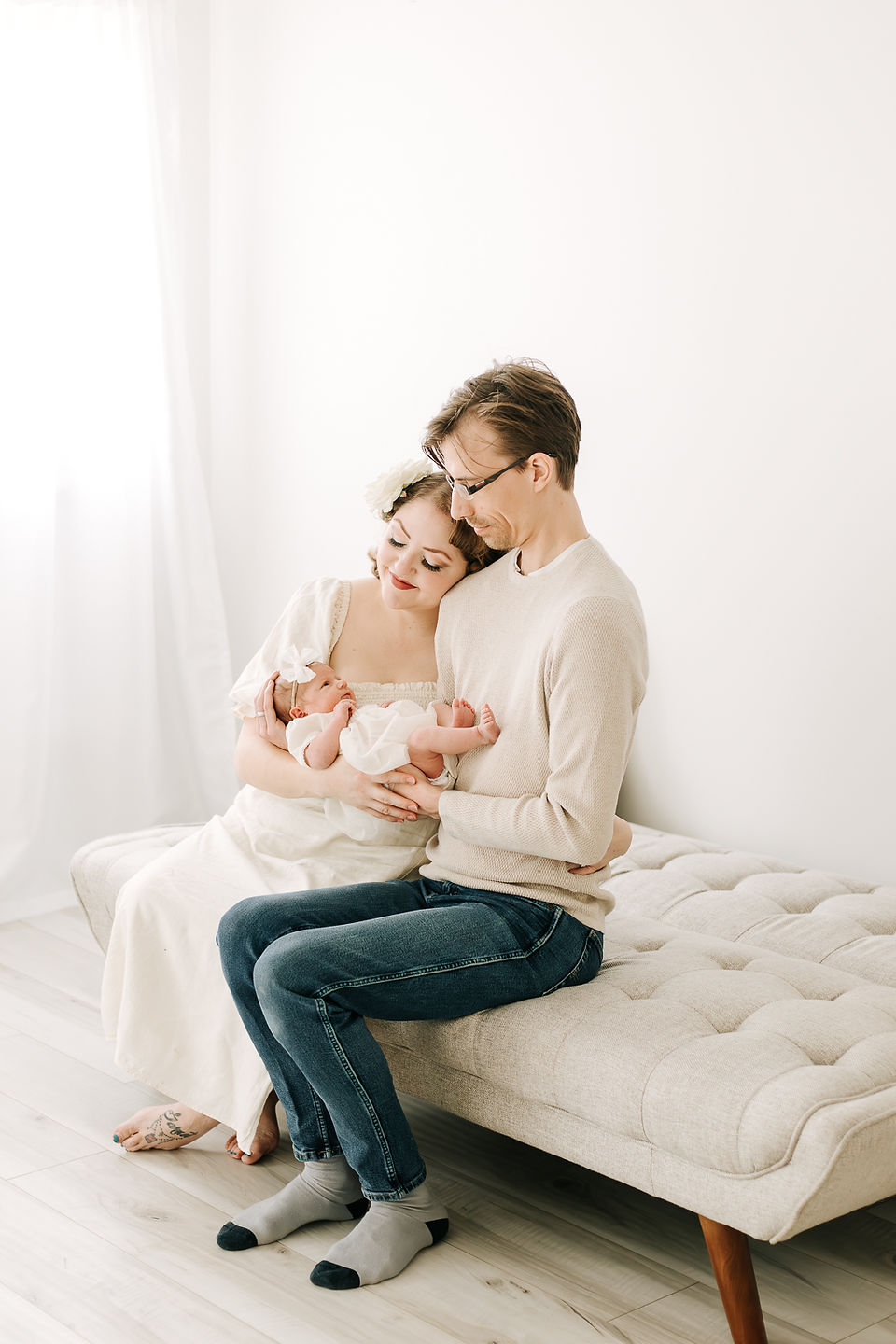 Mom and dad with newborn baby during a newborn session in Guelph, Ontario captured in a soft studio portrait
