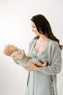 Mother with newborn baby during a newborn session in Guelph, Ontario, captured in a natural light studio setting