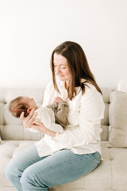 Mother and newborn baby during newborn session in Guelph, Ontario captured in a clean, neutral studio setup