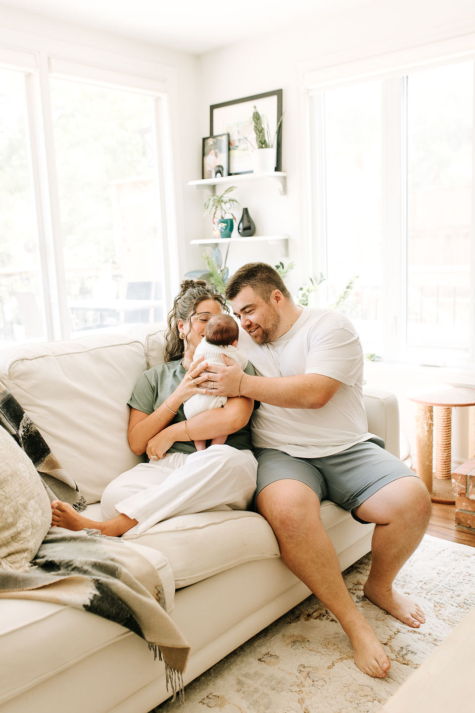 Newborn photography in Guelph, Ontario capturing parents and their baby relaxing together at home in a bright living room