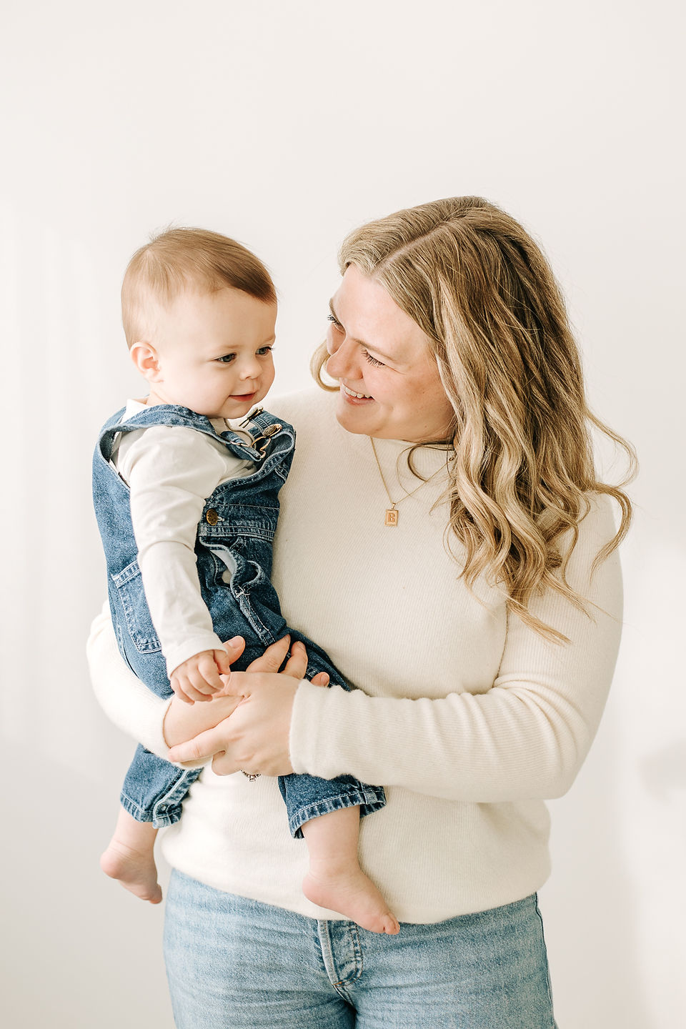 Mother and baby boy together in a first birthday family photoshoot at a photography studio.