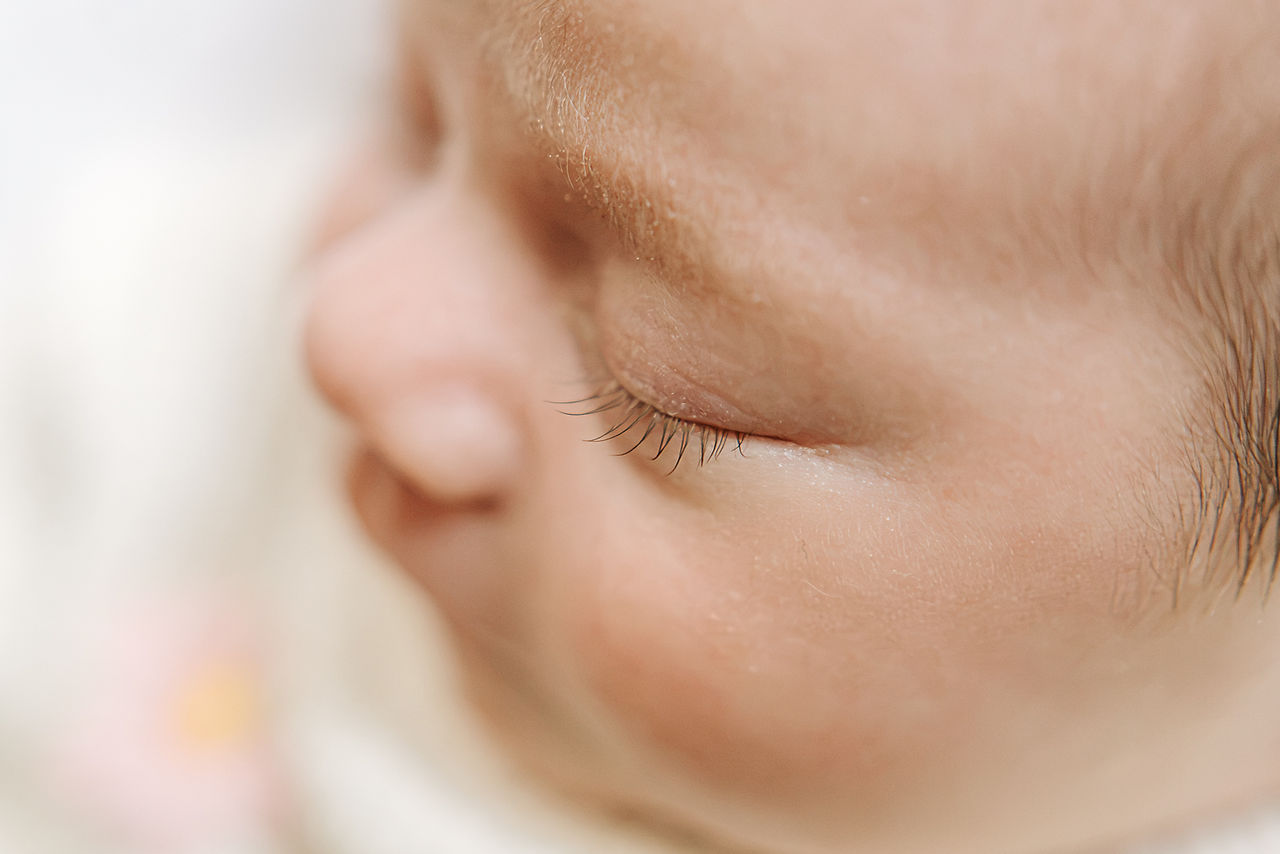 In-home newborn session in Guelph, Ontario focusing on a baby's closed eye, long eyelashes, and soft features