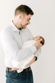 Father and newborn baby portrait during newborn session in Guelph, Ontario captured in a bright, neutral studio setup