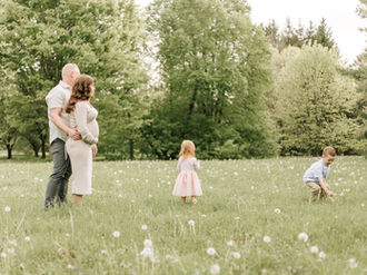 Maternity session in Guelph, Ontario with expecting parents and children in coordinated neutral outfits during a family portrait