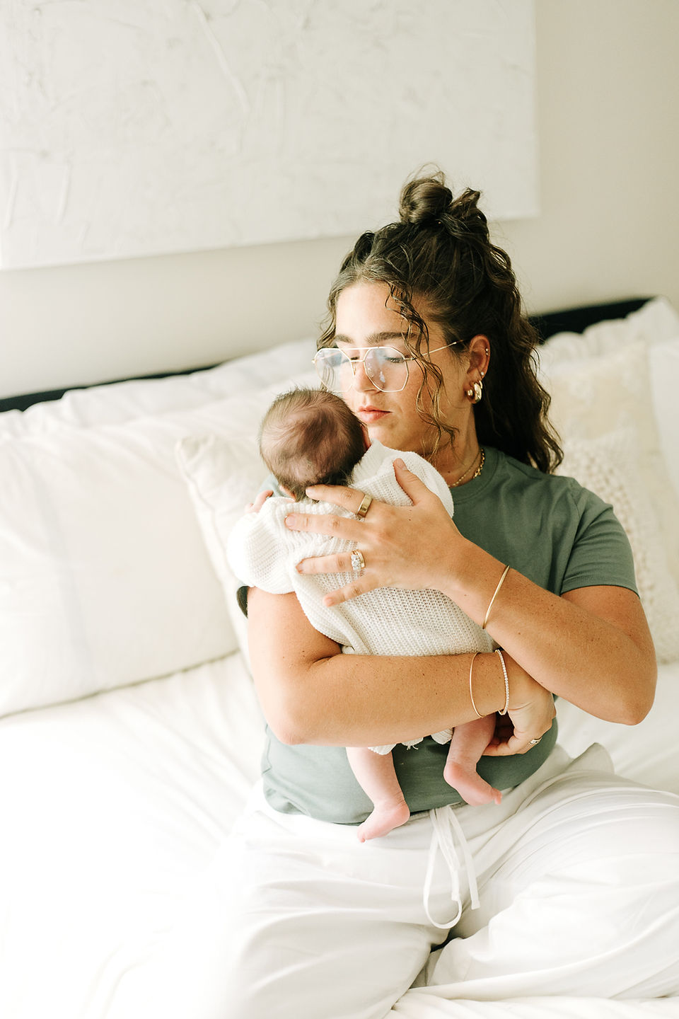 Newborn family session in Guelph, Ontario capturing a tender moment between mother and baby in a cozy bedroom