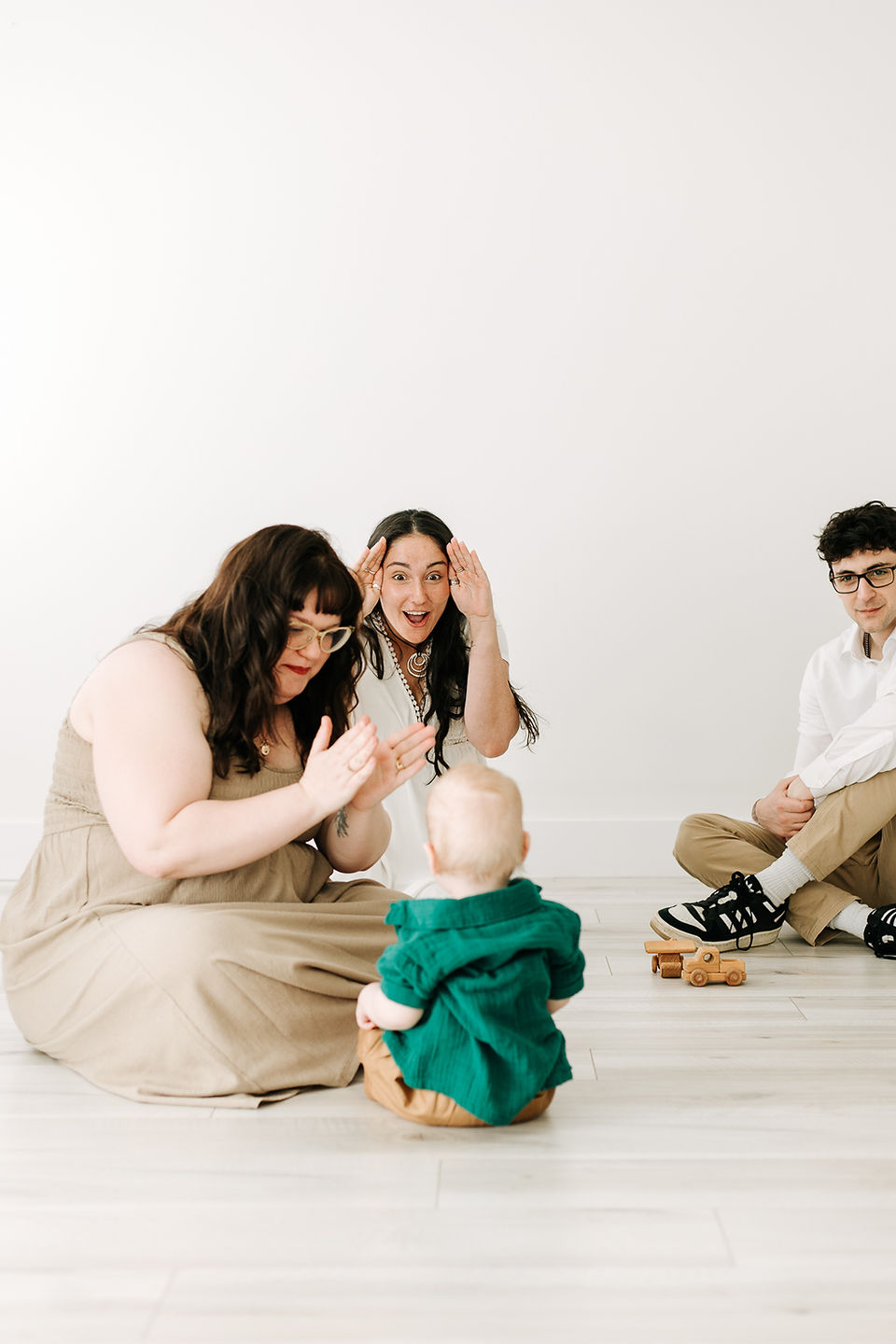 Milestone session in Guelph, Ontario featuring mother, brother, sister, and baby boy playing together in a bright studio setting.