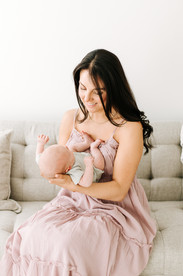 Mother holding newborn baby during a newborn session in Guelph, Ontario in a soft and natural studio portrait