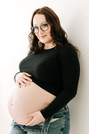 Studio maternity session in Guelph, Ontario highlighting mom and her baby bump in soft lighting